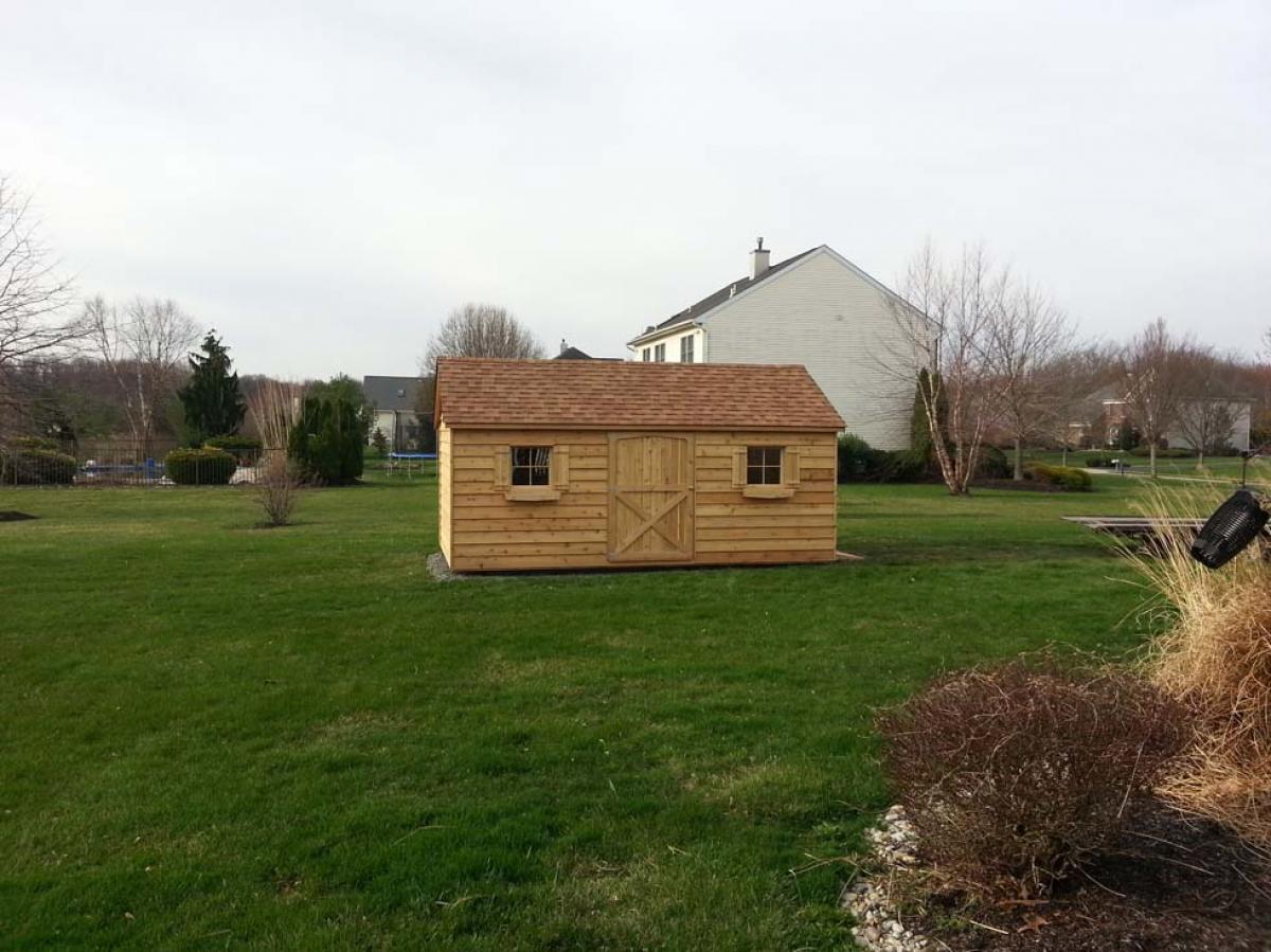 10x16 cedar gable, 48 inch door on front, double 30 inch doors on side with ramp, 2 windows with shutters, 2 window boxes, shakewood roof