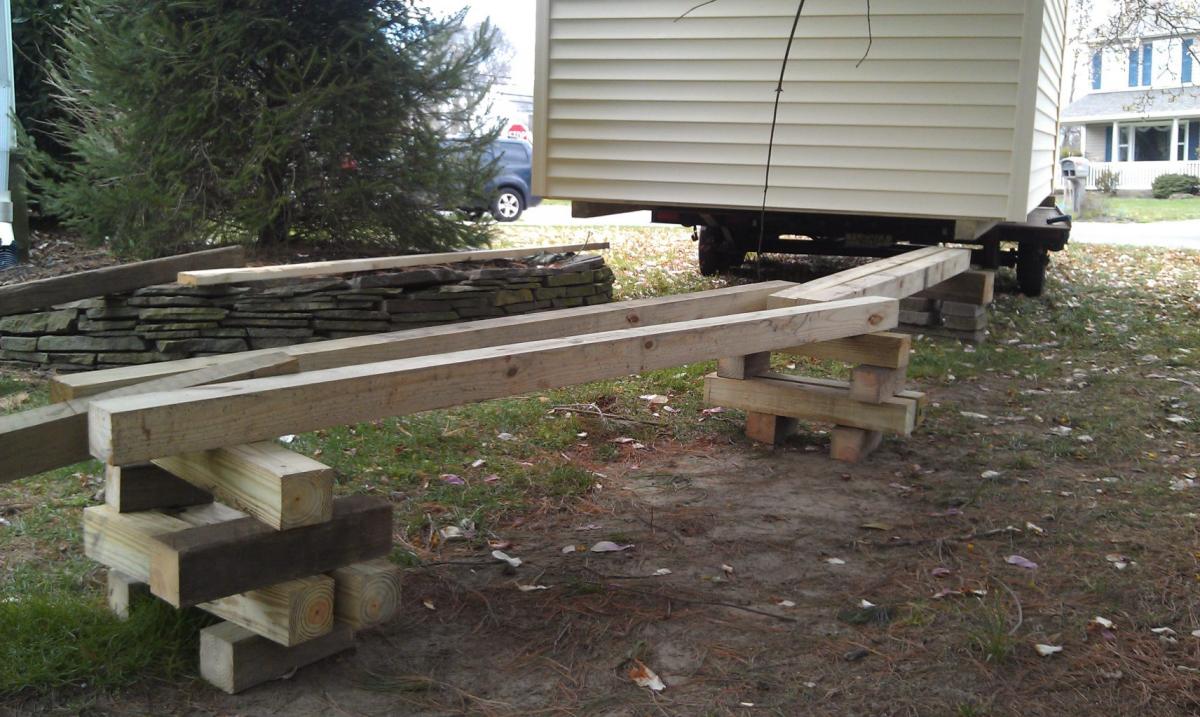We made a bridge using 4x4's to stay level with the elevated landscaping so the shed could be rolled on through.