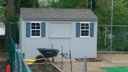 8x12 gray utility gable, 48 inch door, 2 windows, blue shutters, weathered wood roof